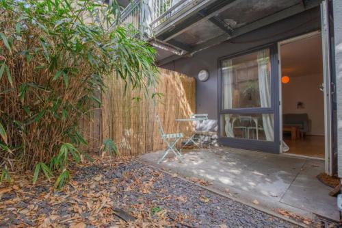 a patio with a table and a chair next to a fence at Spacious 1 Bed apartment near Shoreditch Park in London