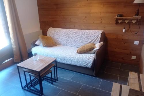 une petite pièce avec un lit et une table dans l'établissement LUMINEUX 30 m avec BALCON- CENTRE VILLAGE, au Monêtier-les-Bains