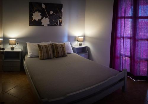 1 Schlafzimmer mit einem großen Bett und 2 Fenstern in der Unterkunft Vretti's apartment in Kýthira