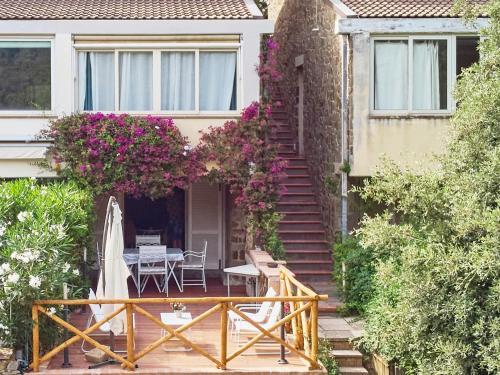una casa con patio con tavolo e fiori di Cottage Punta Ala Residential Area with Pool a Punta Ala