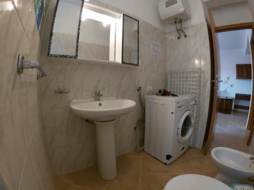 a bathroom with a sink and a washing machine at Casa Bahia 4 in Santa Maria