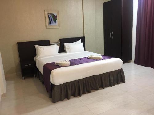 a bedroom with a large bed in a room at Gateway Salalah hotel apartments in Salalah