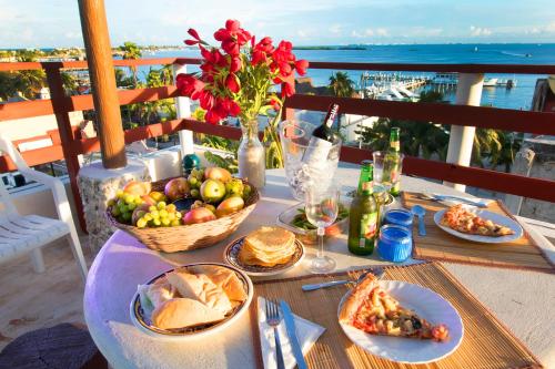 una mesa con platos de comida y una cesta de fruta en Hotel Sol Caribe en Isla Mujeres