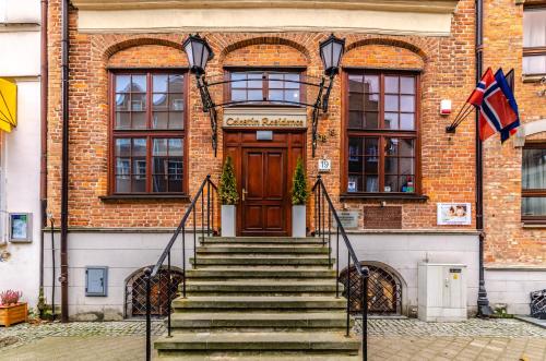 un edificio de ladrillo con escaleras que conducen a una puerta en Celestin Residence, en Gdansk