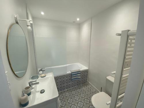 a bathroom with a sink and a mirror and a tub at Maison, Centre-ville, 6 lits, terrasse & parking in Apt