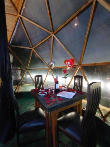 a dining room with a table and two chairs at Glamping Tausavita Ubaté Cundinamarca in El Bujío