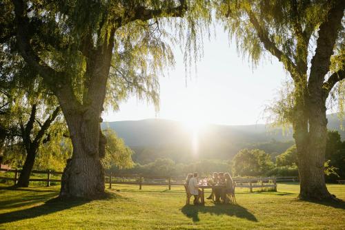 a group of people sitting at a table under trees at Hill Farm Inn - Manchester in Sunderland