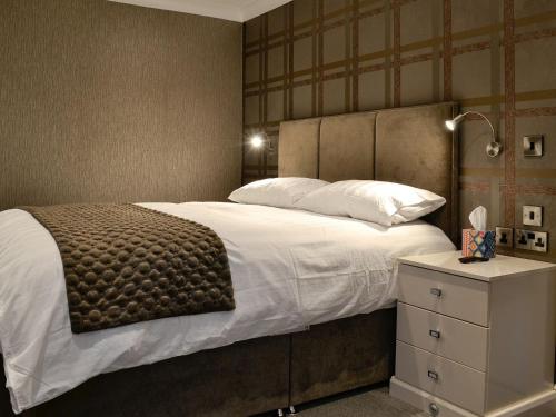 1 dormitorio con 1 cama grande y mesita de noche en Fernhill Cottage, en Oxenhope