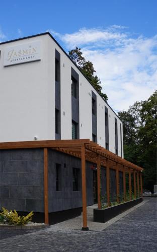 a large white building with a wooden roof at Jaśmin Apartamenty in Krynica Zdrój