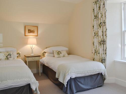 two twin beds in a room with a window at The Garden Suite in Oathlaw