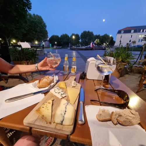 - une table avec deux verres de vin et de fromage dans l'établissement Bel appartement à Bastide St Louis, à Carcassonne