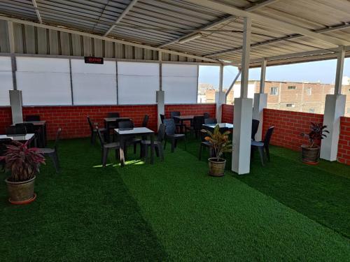 a covered patio with tables and chairs and plants at HOTEL PUNTA PARIÑAS-TALARA-PERU in Talara