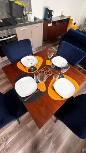 a dining room table with plates and glasses on it at Epernay, appartement champagne Art et Déco in Épernay