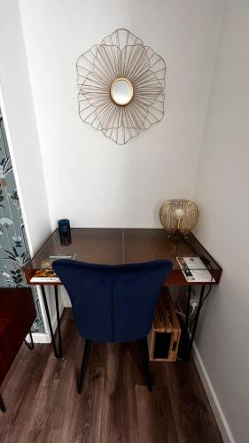 a room with a desk with a blue chair and a fan at Epernay, appartement champagne Art et Déco in Épernay
