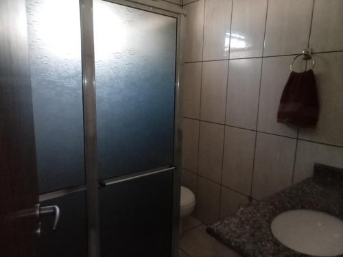 a bathroom with a shower with a toilet and a sink at RECANTO DO ALVORADA in Dourados