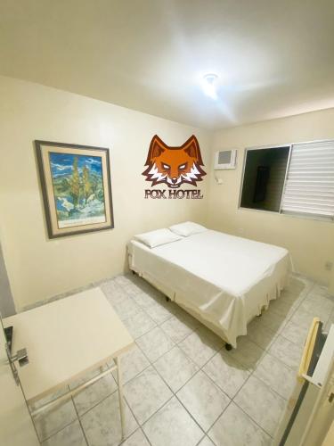 a room with two beds and a fox hotel sign on the wall at Fox Hotel Montes Claros in Montes Claros