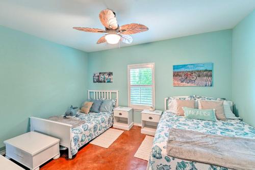 een slaapkamer met 2 bedden en een plafondventilator bij Sunny Townhome with Pool Access about 1 Mi to Beach in Padre Island