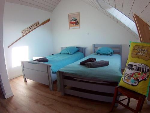 two twin beds in a room with a attic at Le Ty Douar in Coëtmieux