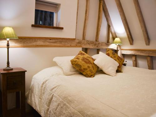 a bedroom with a bed with two lamps on it at Ivy Todd Barn in Ashdon