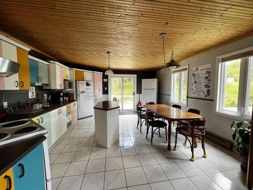 a kitchen with a table and chairs in it at Chill Shack - Auberge Jeunesse in Sainte-Anne-des-Monts