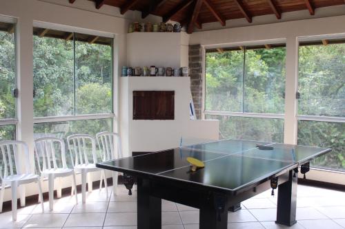 a ping pong table in a room with windows at Pousada Laura e Emílio in Osório