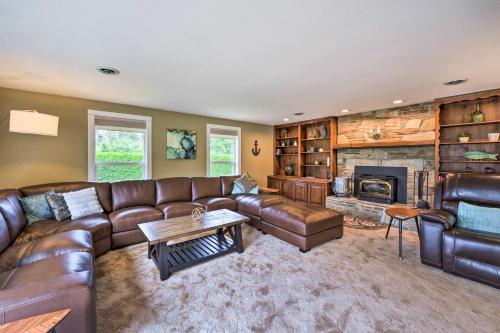 a living room with a leather couch and a fireplace at Peaceful Ranch-Style Camano Home on 5 Acres! in Camano