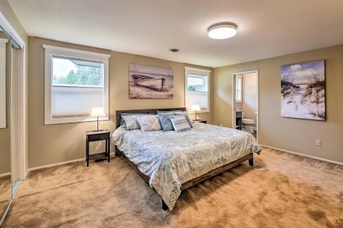 a bedroom with a bed with two lamps and two windows at Peaceful Ranch-Style Camano Home on 5 Acres! in Camano