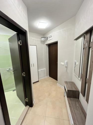 pasillo de un baño con puerta y banco en Apartment Bella, en Veliko Tŭrnovo