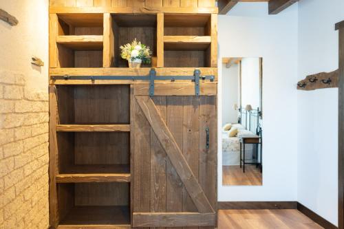 a barn door opens up to a room with wooden shelves at Las Morales Casa Rural 