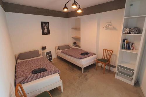 a small room with two beds and a chair at Apartment Steinwald in Oberndorf in Oberndorf