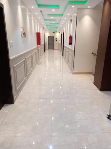 a hallway with a tile floor and green ceilings at هزار الجوف للشقق المخدومة in Al Fayşalīyah