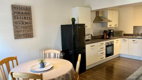 a kitchen with a table and a black refrigerator at City Centre Bridge Street Apartment in Kirkwall