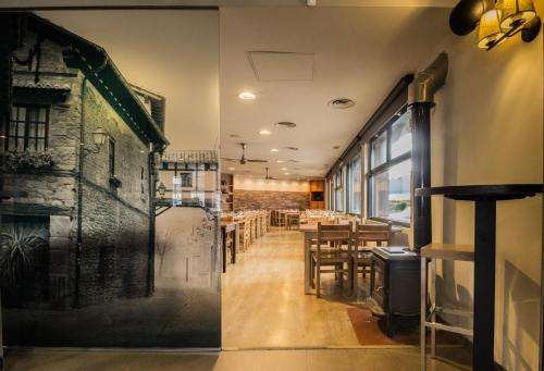a restaurant with a wall mural of a building at Hotel Casa Jacinto Pamplona in Burlada