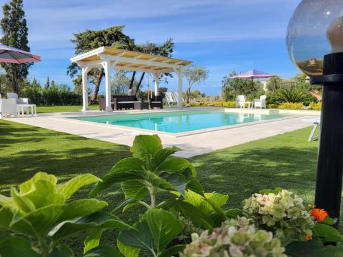 ソルソにあるAntico Casolare Sorso-Tourist Rentalのパーゴラ付きの庭のスイミングプール