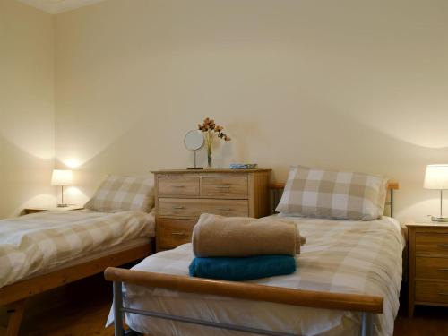 - une chambre avec 2 lits et une commode dans l'établissement Horsemill - Uk10794, à Ballingry