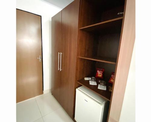a bathroom with a closet with a washer and dryer at Hotel Alexânia in Alexânia