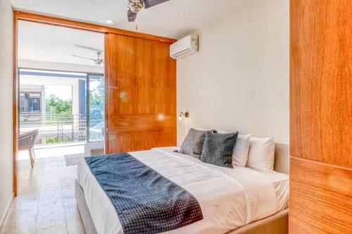 um quarto com uma cama e uma parede de madeira em 301 Amena Spacious Penthouse private Pools and View em Tulum