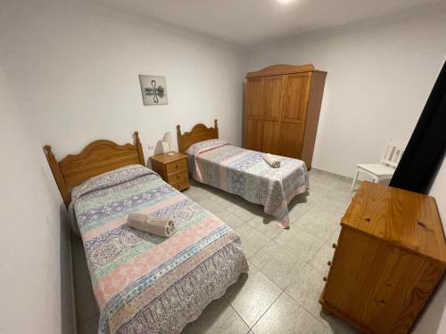 ein Schlafzimmer mit 2 Betten und einer Kommode darin in der Unterkunft Apartamento Playa I & II Arinaga in Arinaga