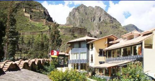 a building with a mountain in the background at Ccapac Inka Ollanta in Ollantaytambo