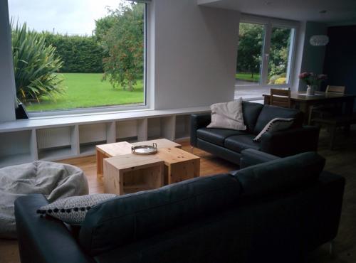 a living room with two couches and a coffee table at Spacious Contemporary Chalet type Apartment. in Galway