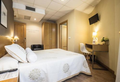 a hotel room with a bed and a desk at Hotel Casa Jacinto Pamplona in Burlada