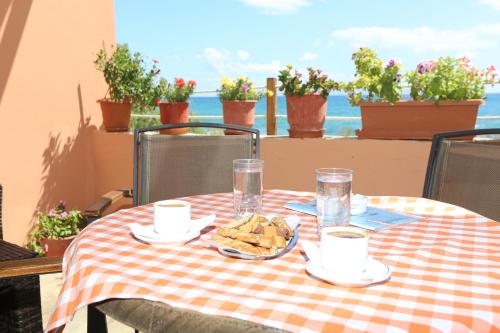 a table with a checkered table cloth with food on it at Akrogiali Hotel in Plomari