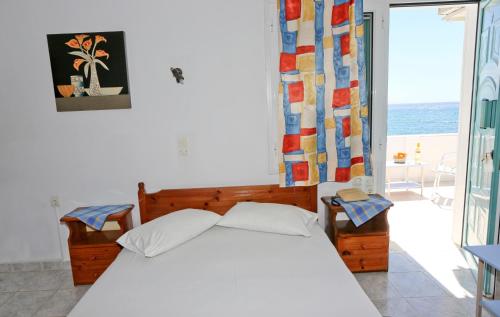A bed or beds in a room at Akrogiali Hotel
