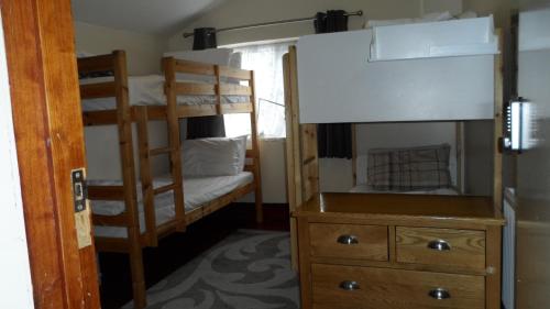 a bedroom with two bunk beds and a dresser at Bubblesbnb 7 Bedroom House, 16 beds, sleeps 22 in London