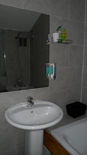 uma casa de banho com um lavatório, um espelho e uma banheira em Bubblesbnb 7 Bedroom House, 16 beds, sleeps 22 em Londres