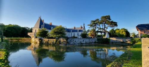 a view of a river with a house and a building at Appartement lumineux et cosy avec jardin vue sur chateau près Port en Bessin, Bayeux et Omaha Beach in Commes