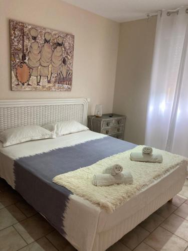 1 dormitorio con 1 cama con 2 toallas en Appartement PALAZZI 1, en LʼÎle-Rousse