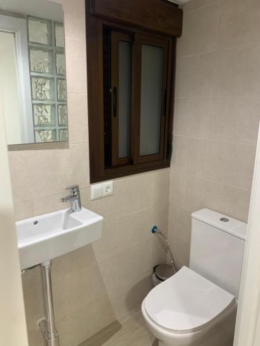 a bathroom with a toilet and a sink and a mirror at La Vida es Bella in Setenil