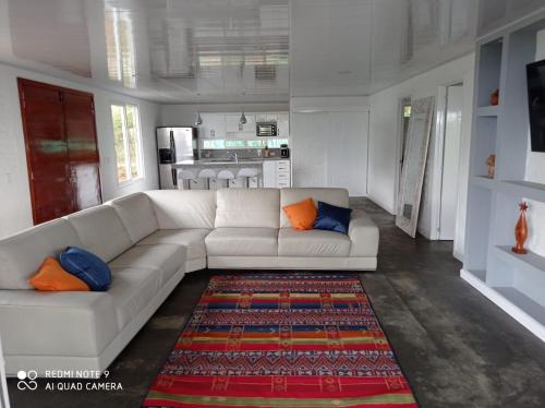 a living room with a white couch and a rug at Villa las Águilas 1 in Borrero Ayerbe