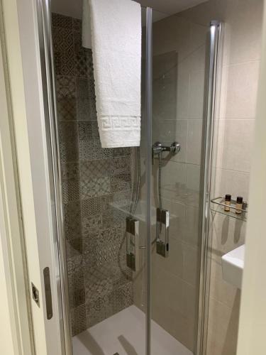 a bathroom with a shower with a glass door at La Vida es Bella in Setenil